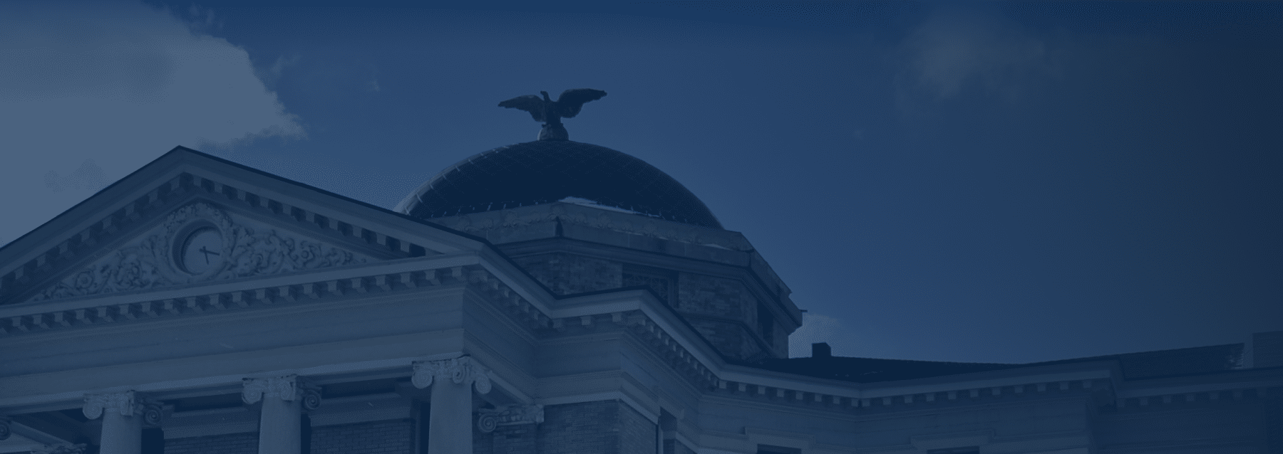A statue of an eagle in flight on top of a state capital building. 