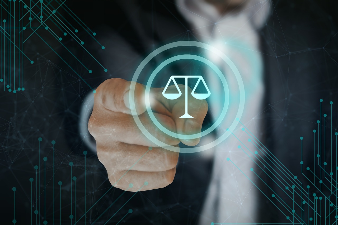 An image of the scales of justice, a finger pointing is in the background.